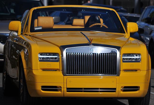 A yellow car parked in a parking lotDescription automatically generated with low confidence